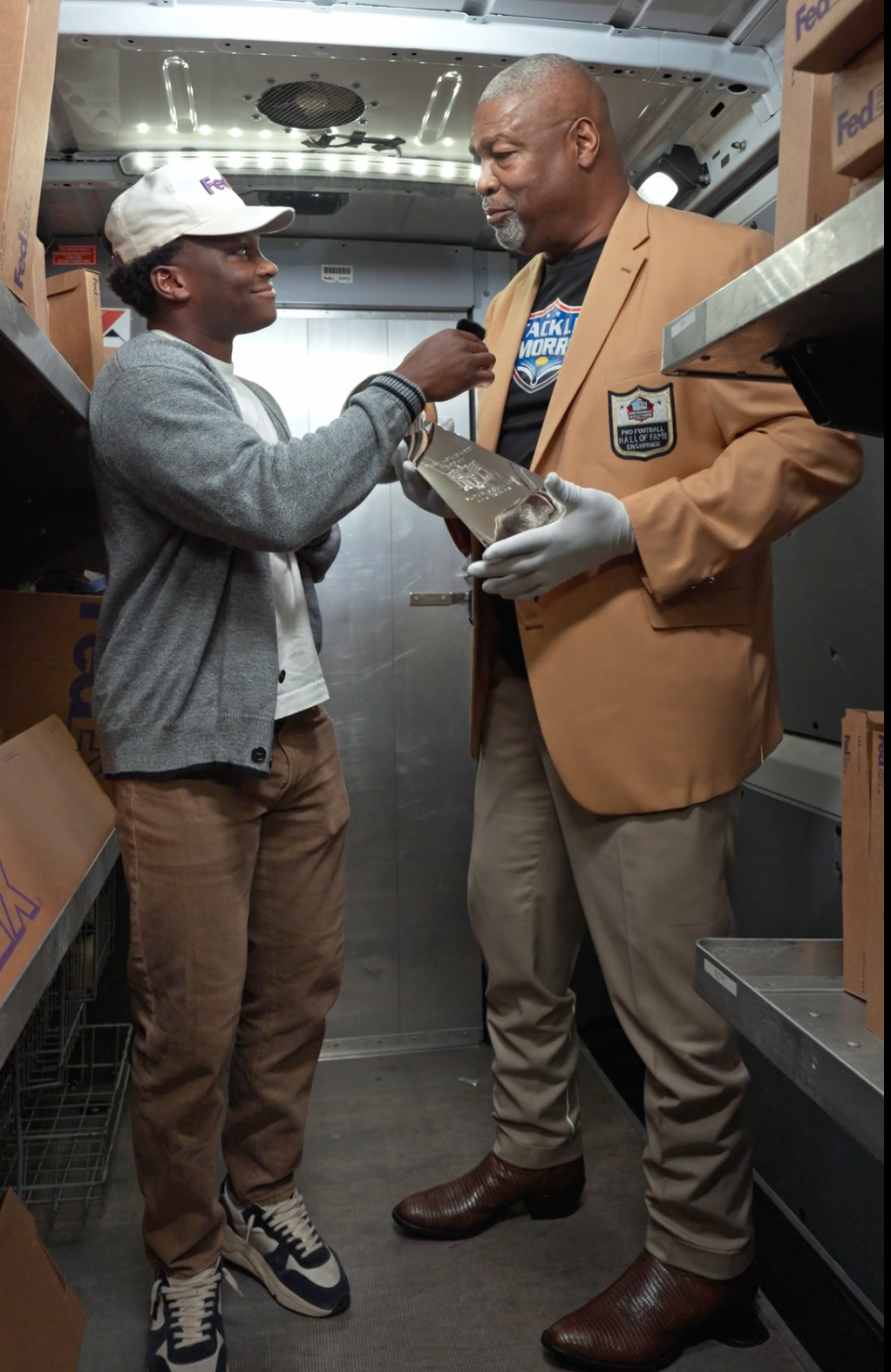 Titus Gardner interviewing a Pro Football Hall of Famer inside a FedEx vehicle